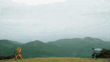 a man and a robot are standing on a grassy hillside