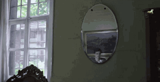 a painting of a man is reflected in a round mirror