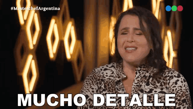 a woman in a leopard print shirt says mucho detalle in spanish