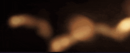 a blurry picture of a person holding a candle in the dark .