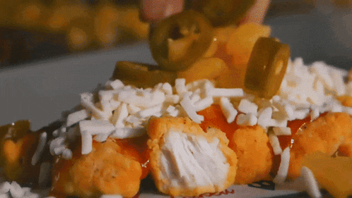 a plate of food with jalapenos and cheese on it