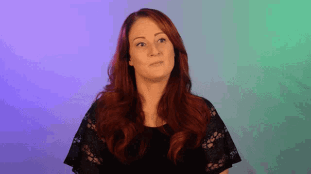 a woman with red hair wearing a black lace top