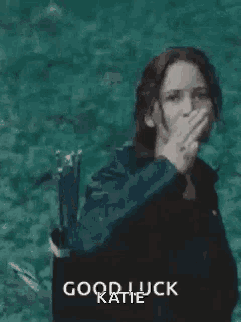 a woman is giving the middle finger in front of a body of water and says `` good luck katie '' .