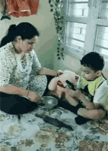 a woman and a child are sitting on the floor playing with a toy