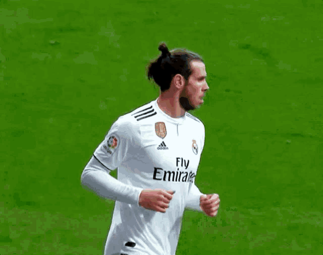 two soccer players one wearing a fly emirates jersey