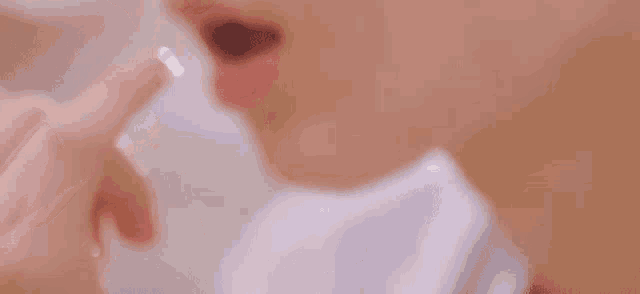 a close up of a person taking a pill with their finger in their mouth .
