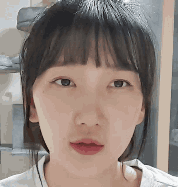 a close up of a girl 's face with a white shirt