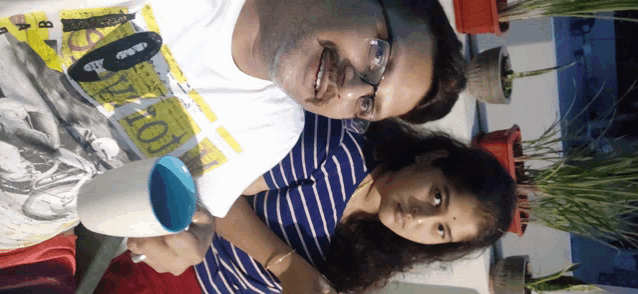 a man and a girl are posing for a picture and the man is wearing a shirt that says ' 100 ' on it
