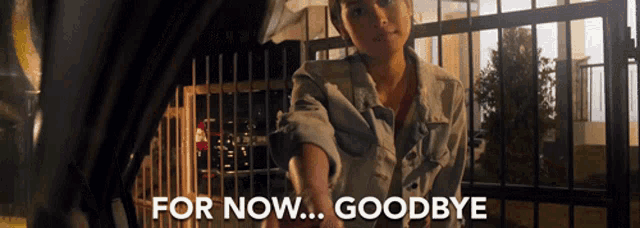 a woman reaches out to shake someone 's hand with the words " for now goodbye " above her