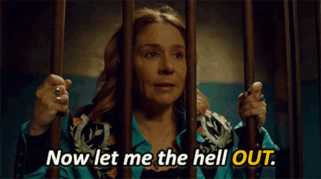 a woman in a jail cell with the words now let me the hell out