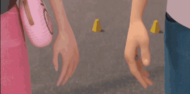 a man and a woman are holding hands in front of yellow cones