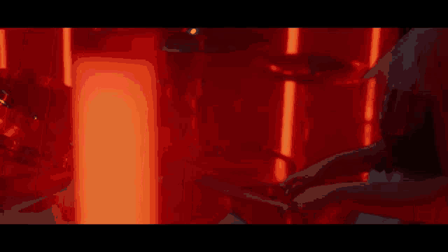 a close up of a person playing drums in a dark room with red lights .