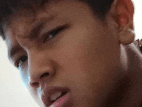 a close up of a young man 's face with a serious expression .