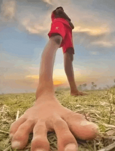 a person 's foot is reaching out towards another person 's foot in the grass .