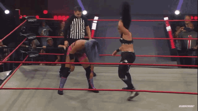 two women are wrestling in a ring with a referee and the word impact on the ring