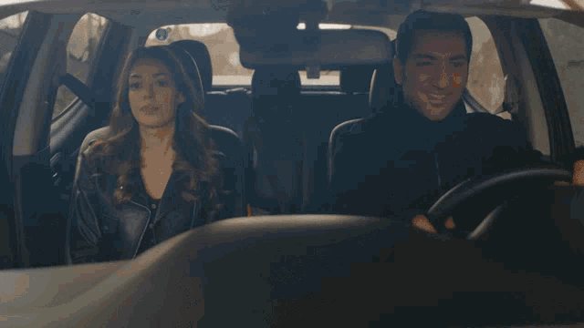 a man and a woman are sitting in the back of a car