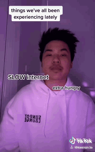 a man wearing a white hoodie with the words slow internet extra hungry written on the front