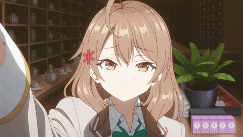 a girl with brown hair and a flower in her hair looks at the camera