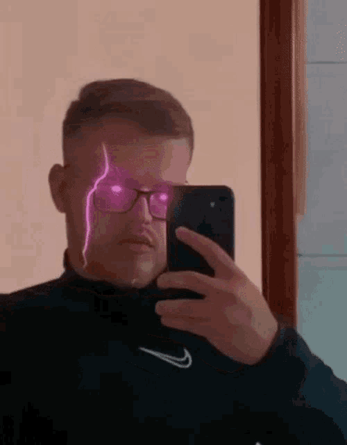 a man is taking a selfie with a lightning bolt coming out of his eyes .