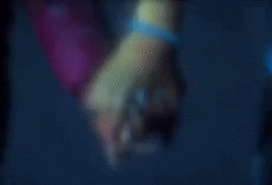 a person is holding a glowing object in their hand in a dark room .