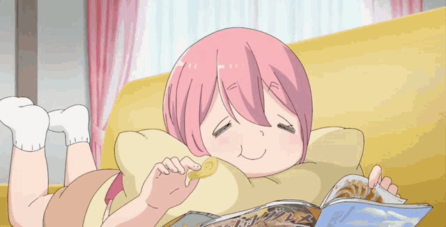 a girl with pink hair is laying on a couch eating chips and reading a magazine