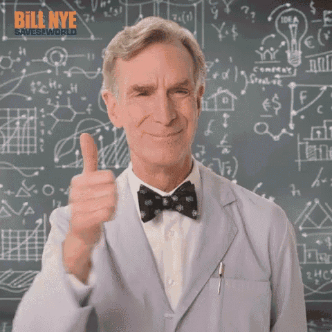 a man in a suit and bow tie is giving a thumbs up in front of a chalkboard .