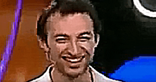 a man is smiling and looking at the camera