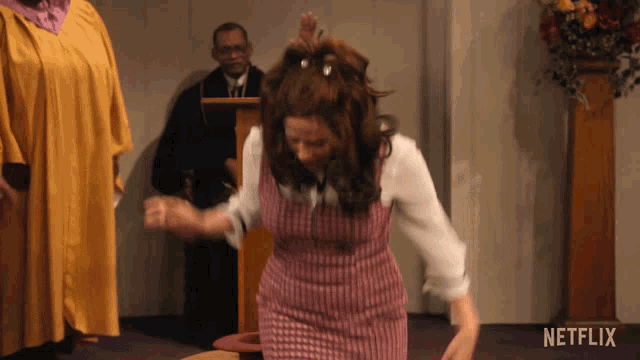 a woman in a pink dress is dancing in a church with a netflix logo in the background