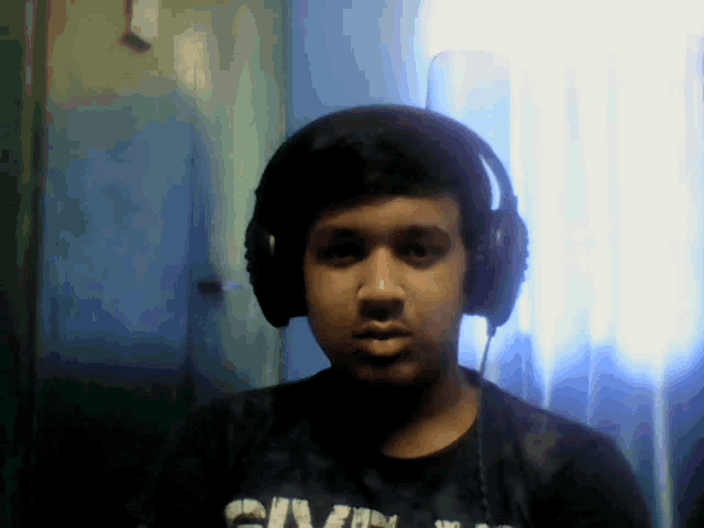 a young man wearing headphones and a black shirt with the word givenchy on it