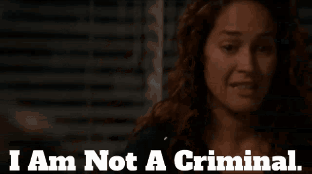 a woman says " i am not a criminal " in front of a dark background