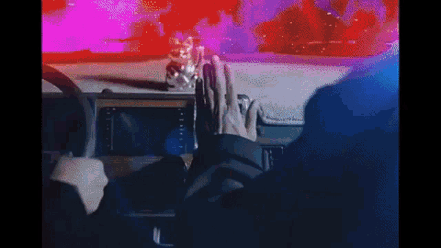a person is driving a car with their hands on the dashboard