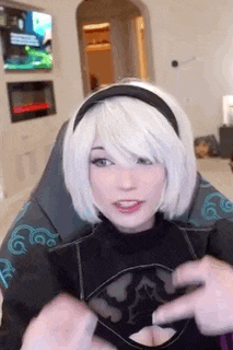 a woman in a white wig is sitting in a chair and talking to a man .