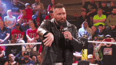 a man in a wrestling ring with a microphone that says nxt