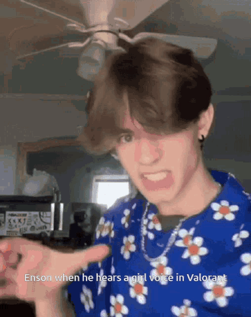 a man wearing a blue shirt with flowers on it is pointing