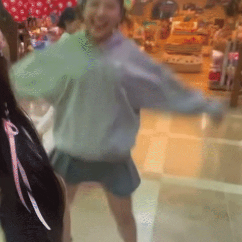 a woman in a sweatshirt and shorts is dancing in a store .