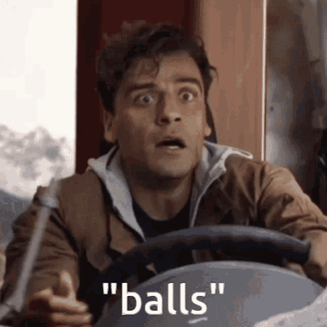 a man in a brown jacket is driving a car and saying " balls " .