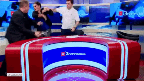 a man and a woman are fighting in front of a tv screen that says russian on it