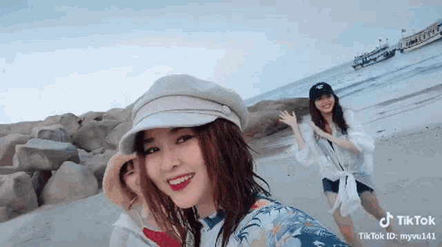 a group of women are posing for a picture on the beach .