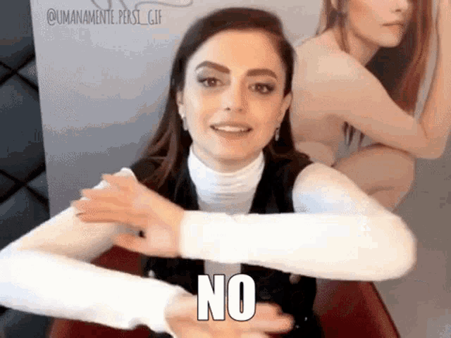 a woman is making a no sign with her hands .