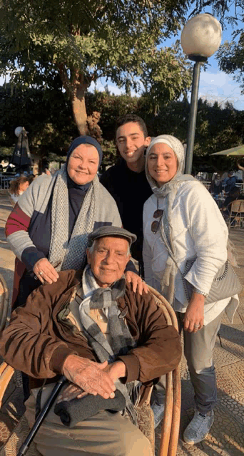a group of people posing for a picture including an older man
