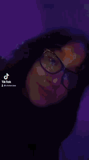 a girl is laying on a bed in front of a computer .