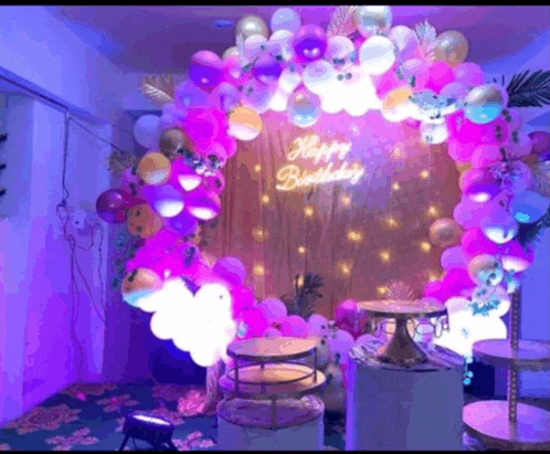 a room decorated with balloons and a sign that says happy birthday .