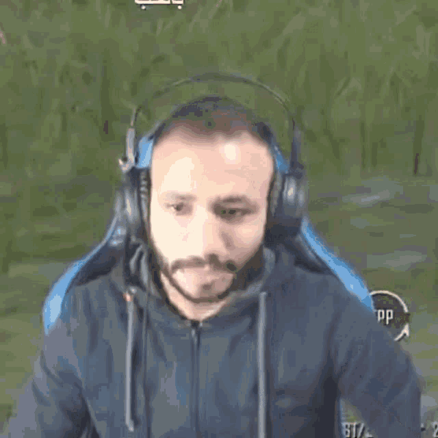 a man wearing headphones is screaming in front of a green background ..