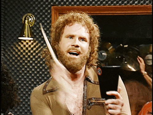 a man with a beard is holding a drum stick and a glass of beer