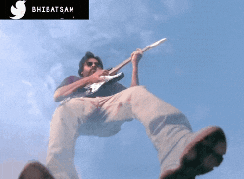 a man is playing a guitar in the sky with the twitter logo above him