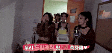 a group of women are standing in a room holding a cake and a trophy .