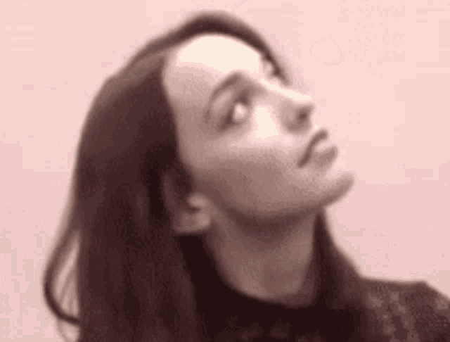 a woman with long hair is looking up at the sky .