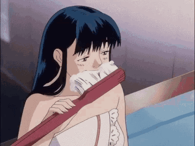 a girl in a towel is brushing her teeth with a red toothbrush .