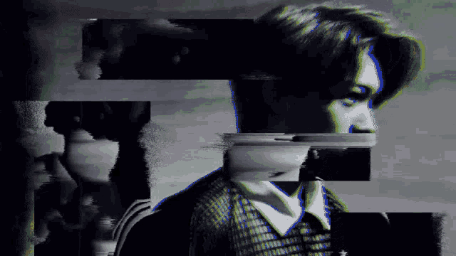 a black and white photo of a man 's face is being displayed in a glitch effect .