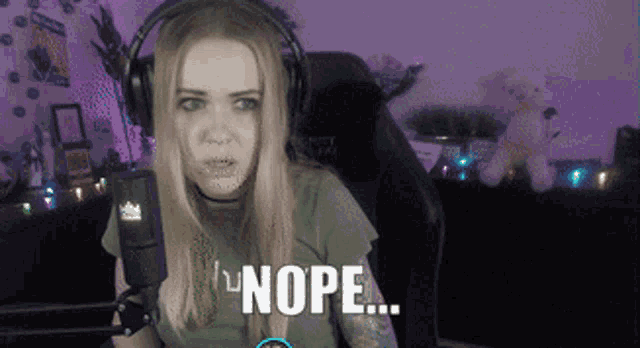 a woman wearing headphones is holding a microphone and says nope